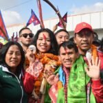 Palesha Goverdhan (C) poses with her medal upon her arrival at the Kathmandu airport. [Prakash Mathema/AFP]